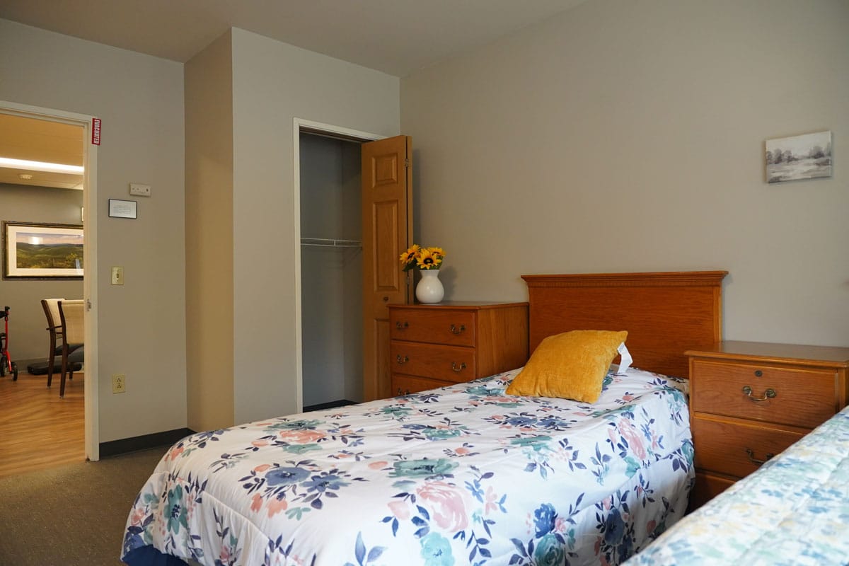 Interior view of a resident room with twin beds and dresser