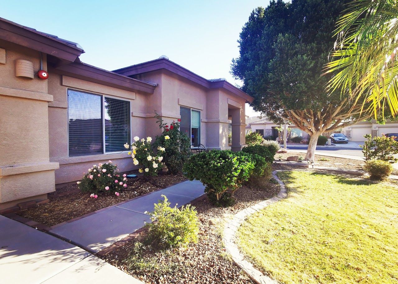 Front exterior of a residential assisted living home with garden