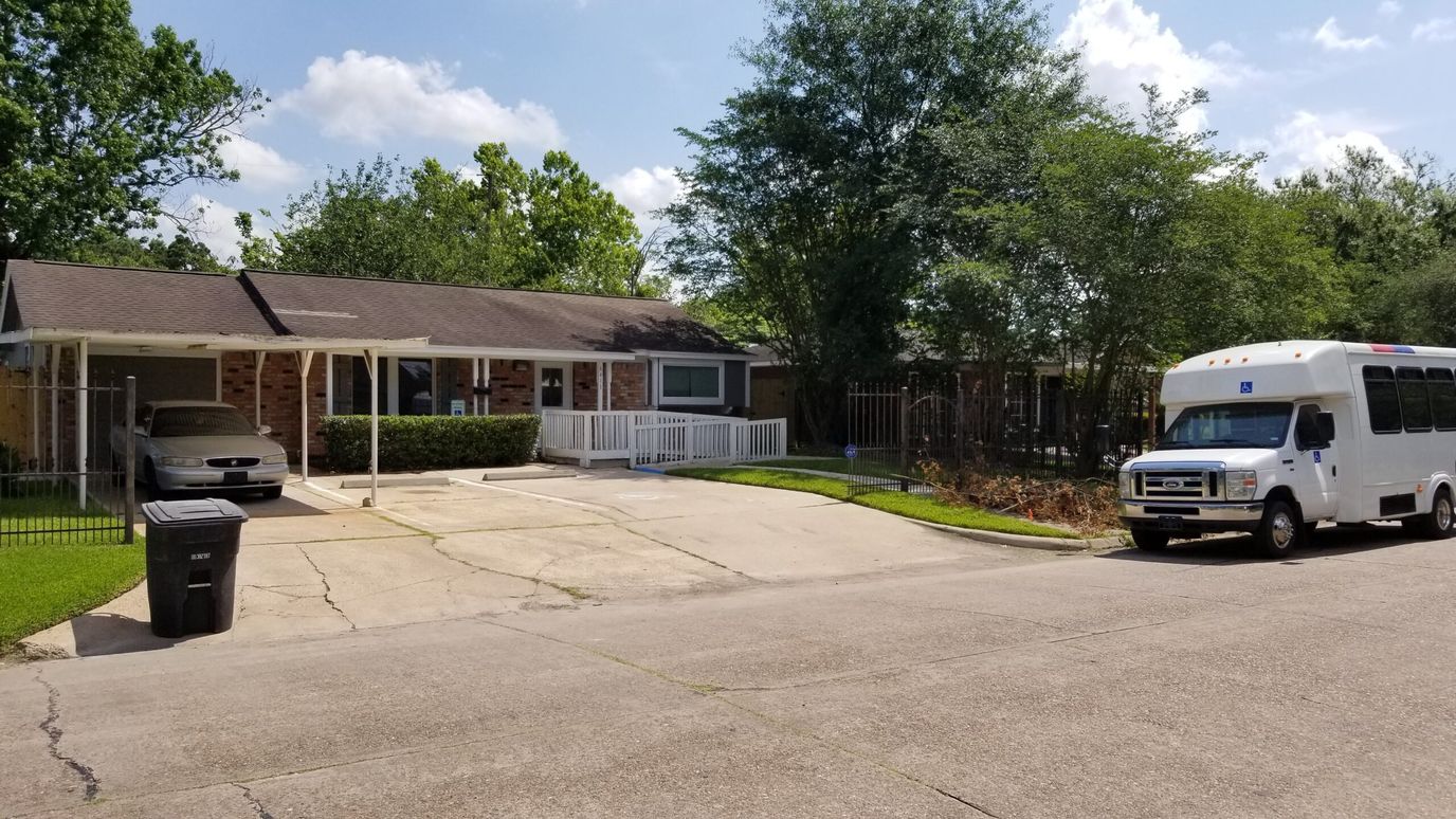 Exterior view of House of Hearts Assisted Living with shuttle bus