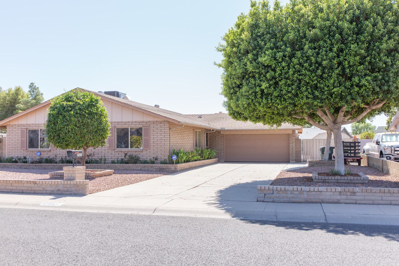 Exterior view of a beige house with landscaping