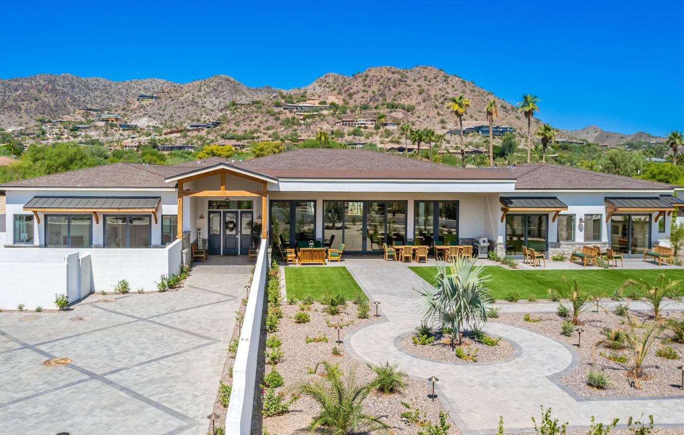 Exterior view of a senior living facility with mountains in the background