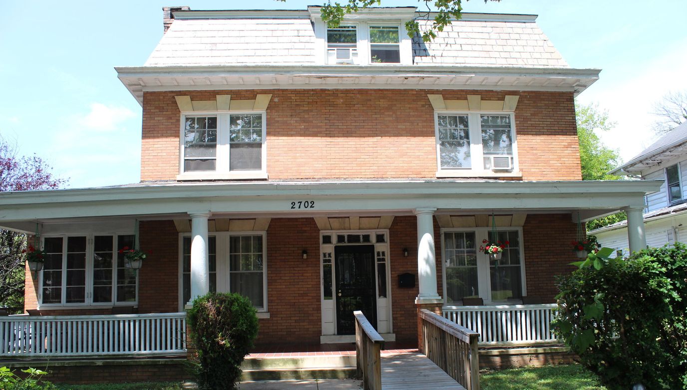 Exterior view of a brick building with a ramp and porch