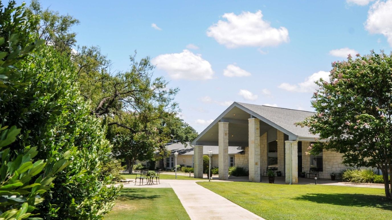 Exterior view of a senior living facility surrounded by greenery