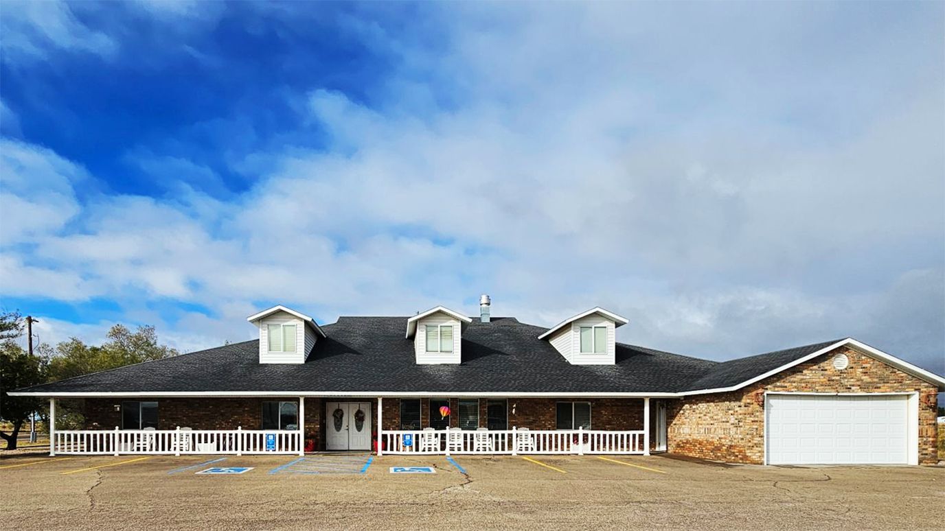Exterior view of BeeHive Homes facility with blue sky