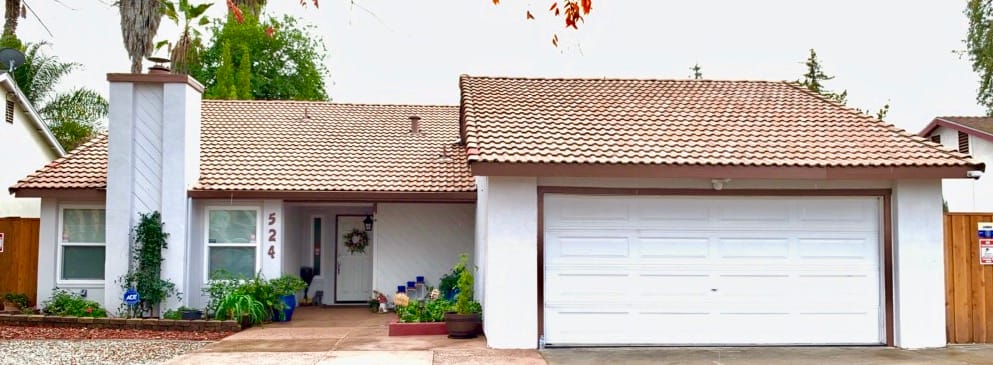 Exterior view of a residential building with a landscaped front yard