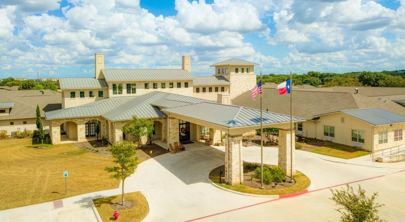 Exterior view of The Auberge at Cedar Park with flags