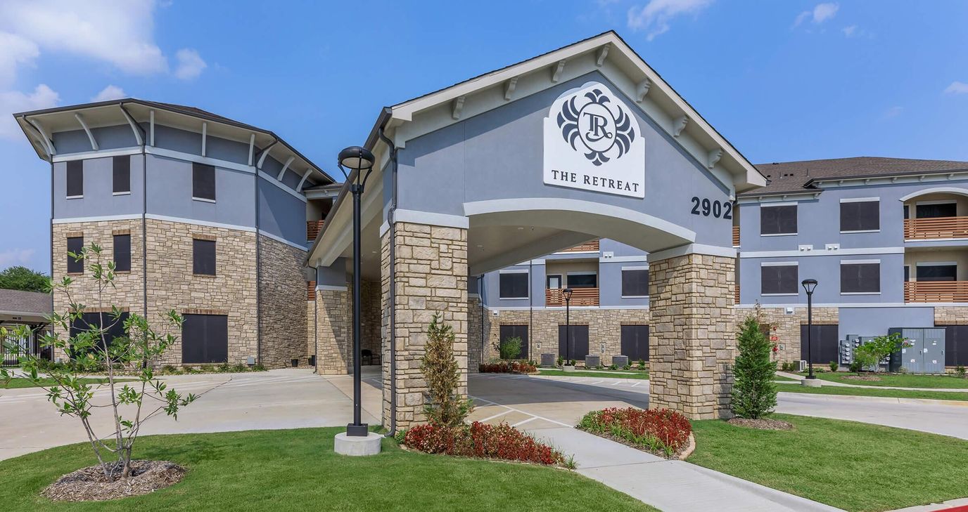 Exterior view of The Retreat Senior Living building with logo