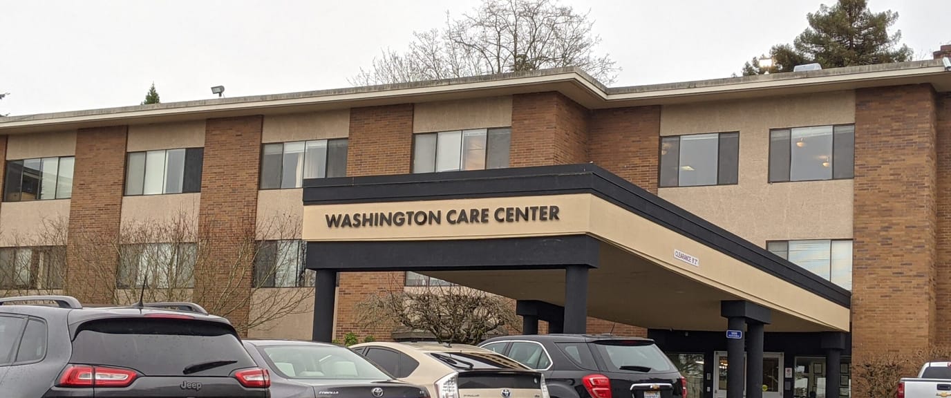 Entrance of Washington Care Center with vehicles parked