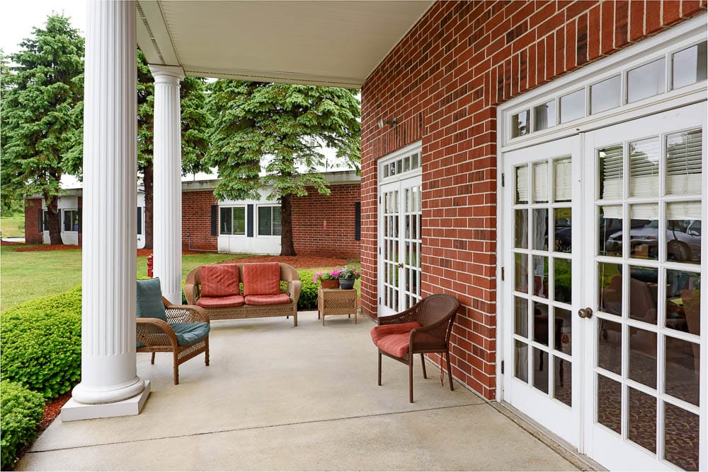 Outdoor seating area with comfortable chairs and greenery