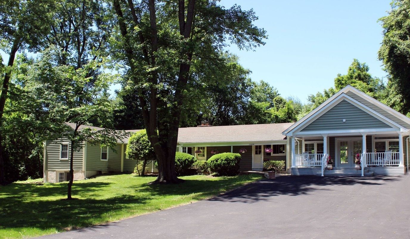 Exterior view of Clifton Woods Memory Care Home surrounded by trees