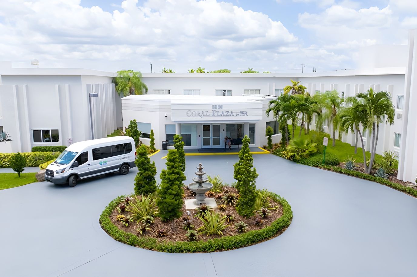 Exterior view of Coral Plaza with landscaping and facility van