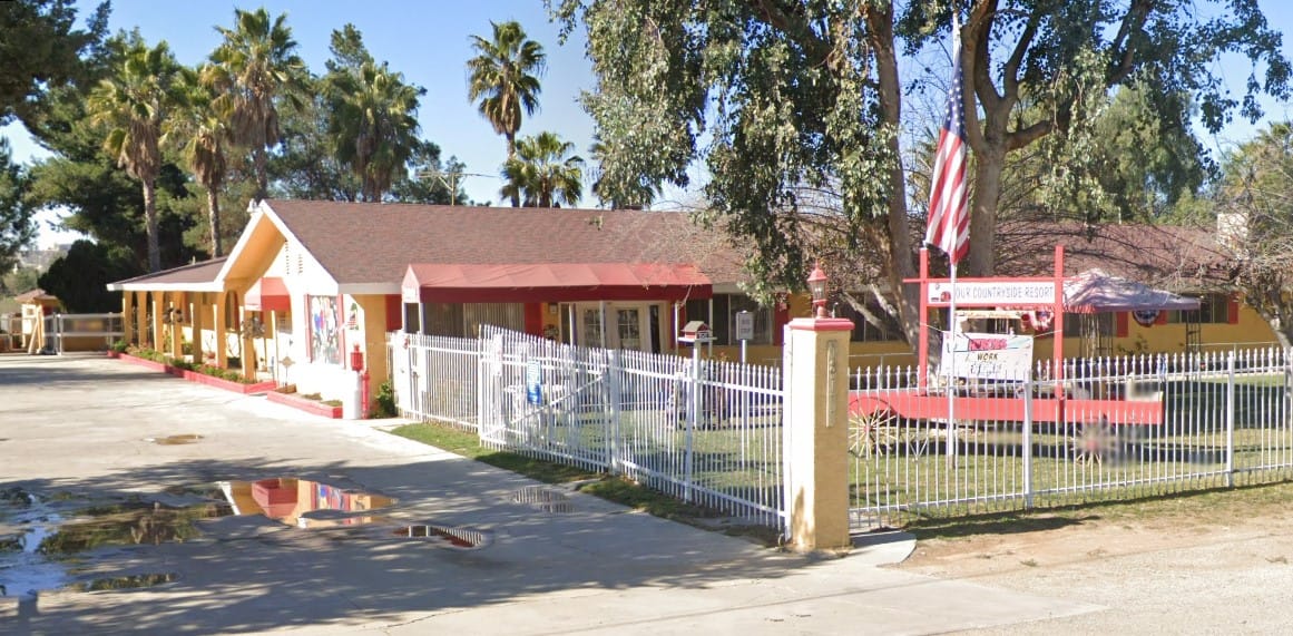 Exterior view of Memory Care facility with garden and fence