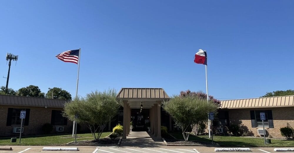 Exterior view of The Collinwood Care Center with flags