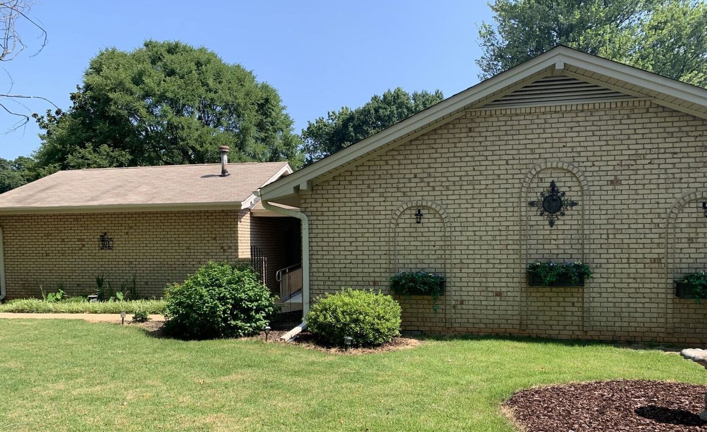 Exterior view of a brick building with garden