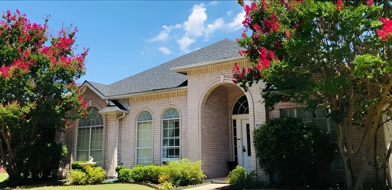 Exterior view of a senior living facility with gardens