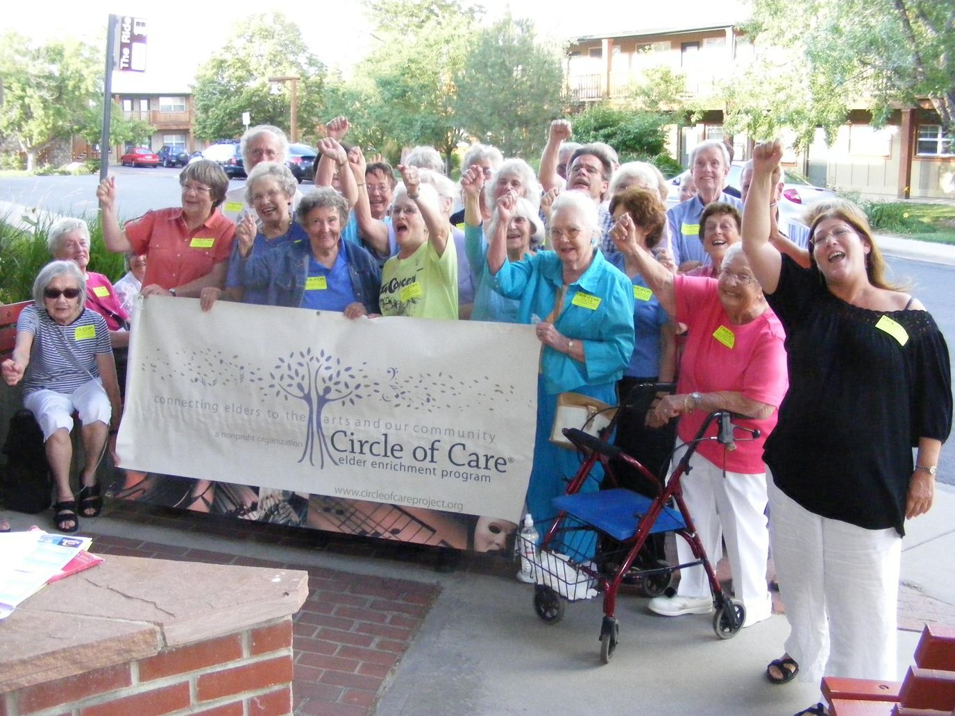 Residents celebrating outdoors with a banner