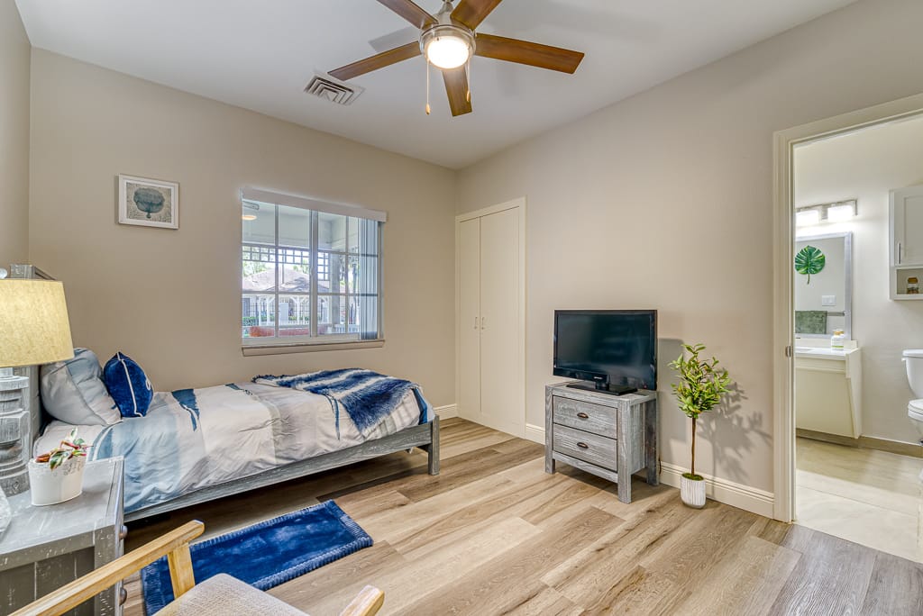 Comfortable bedroom with bed, TV, and window.