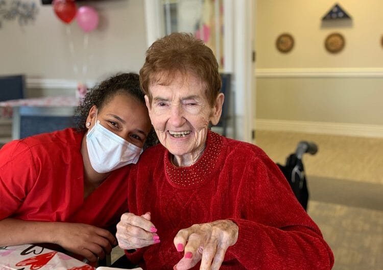 A staff member and resident smiling together