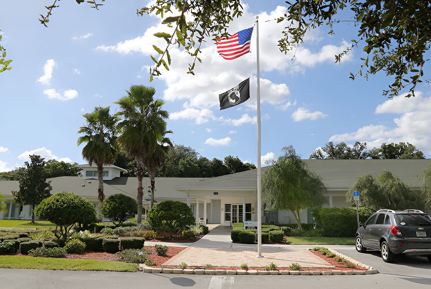 Exterior view of Marliere Hospice House with flags and landscaping