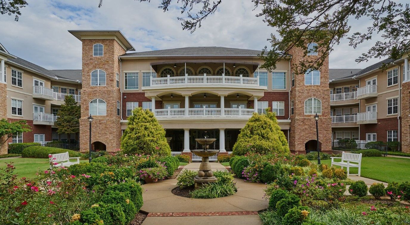Exterior view of a senior living facility with landscaped gardens