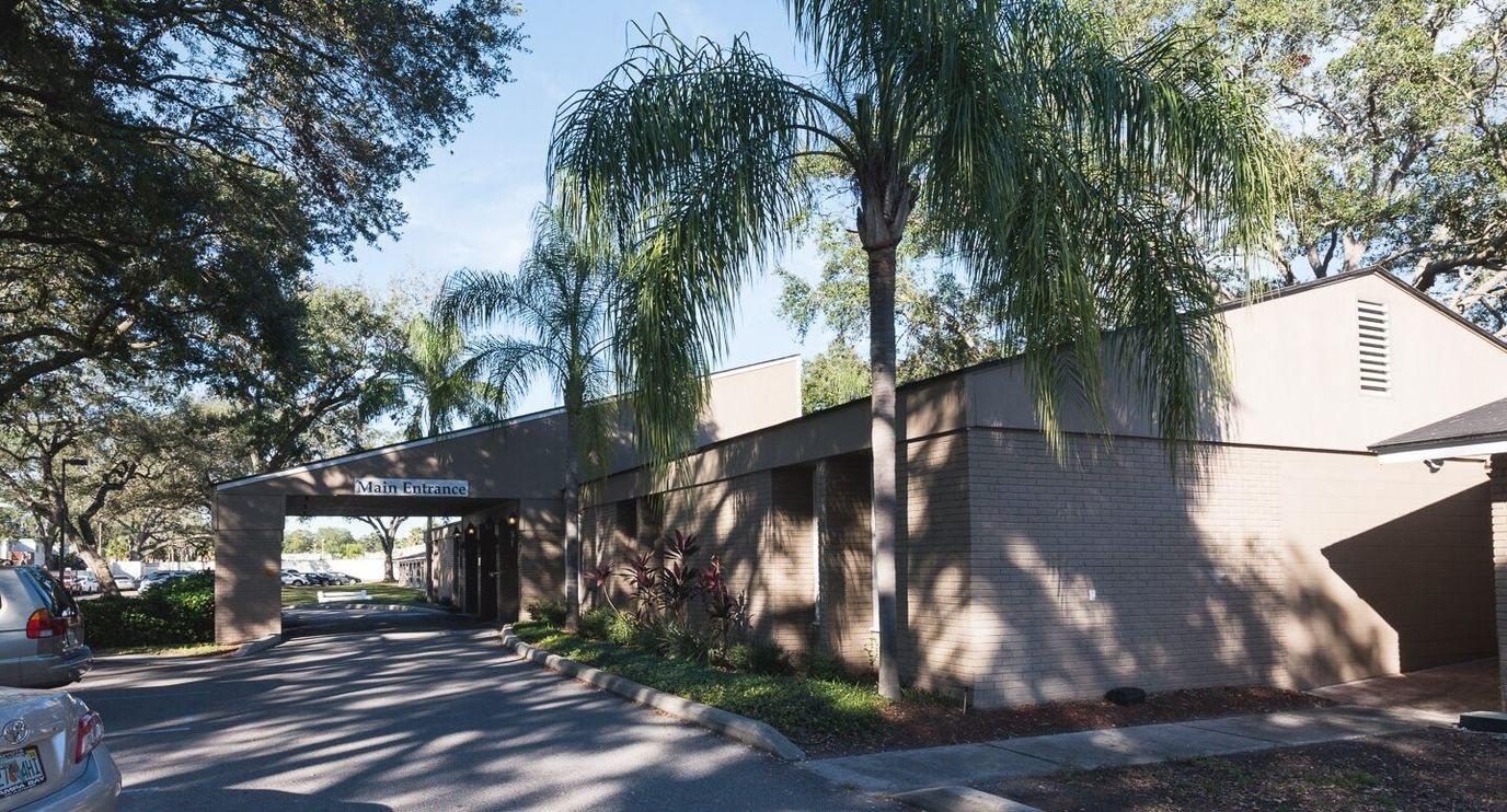 Exterior view of the nursing facility with palm trees