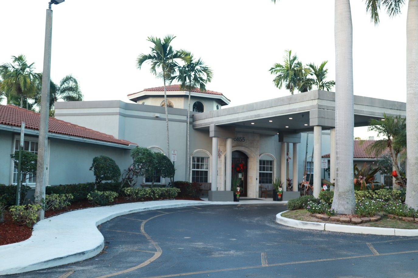 Front entrance of HarborChase of Tamarac with landscaping