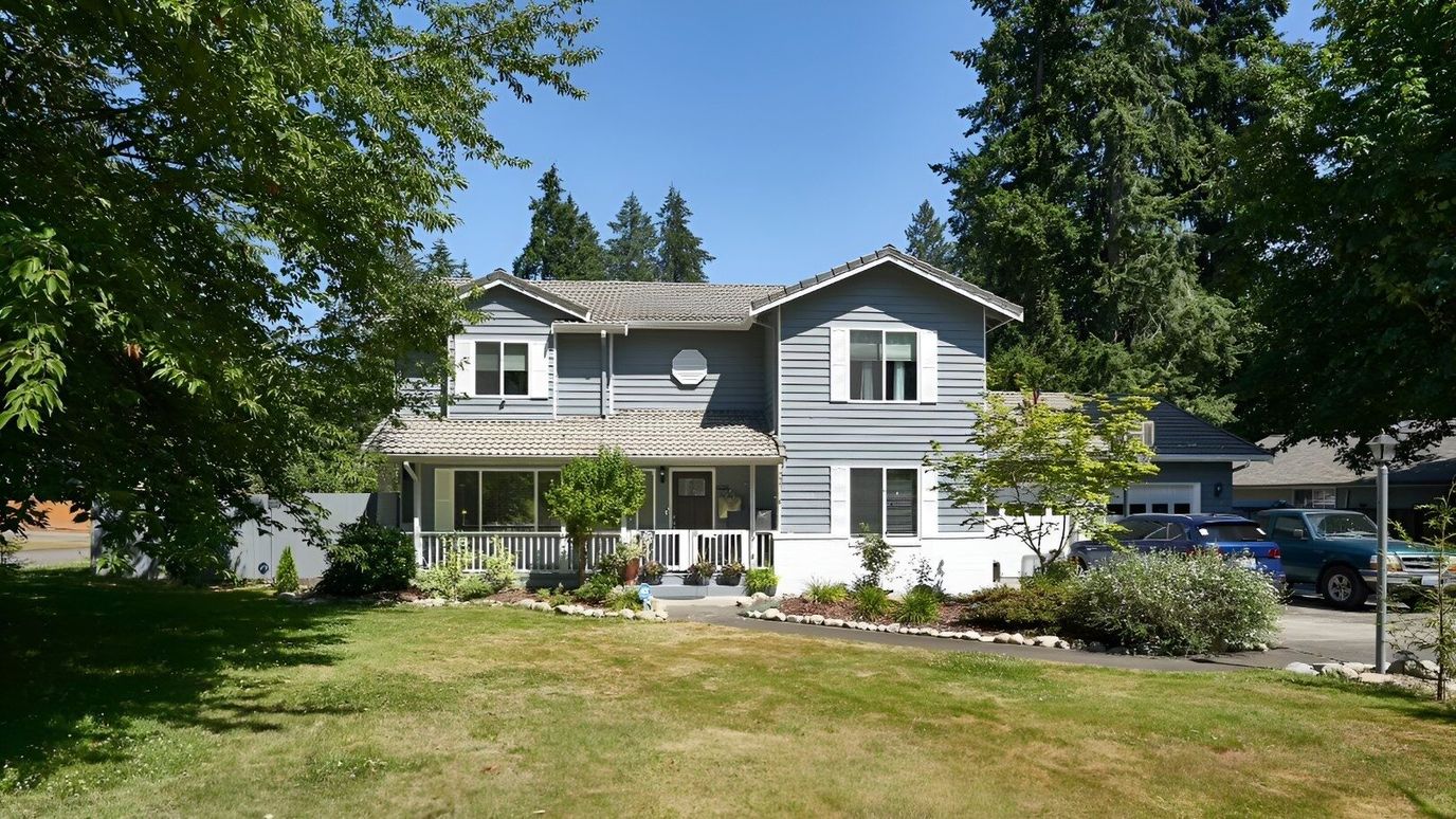 Exterior view of a gray two-story home with garden