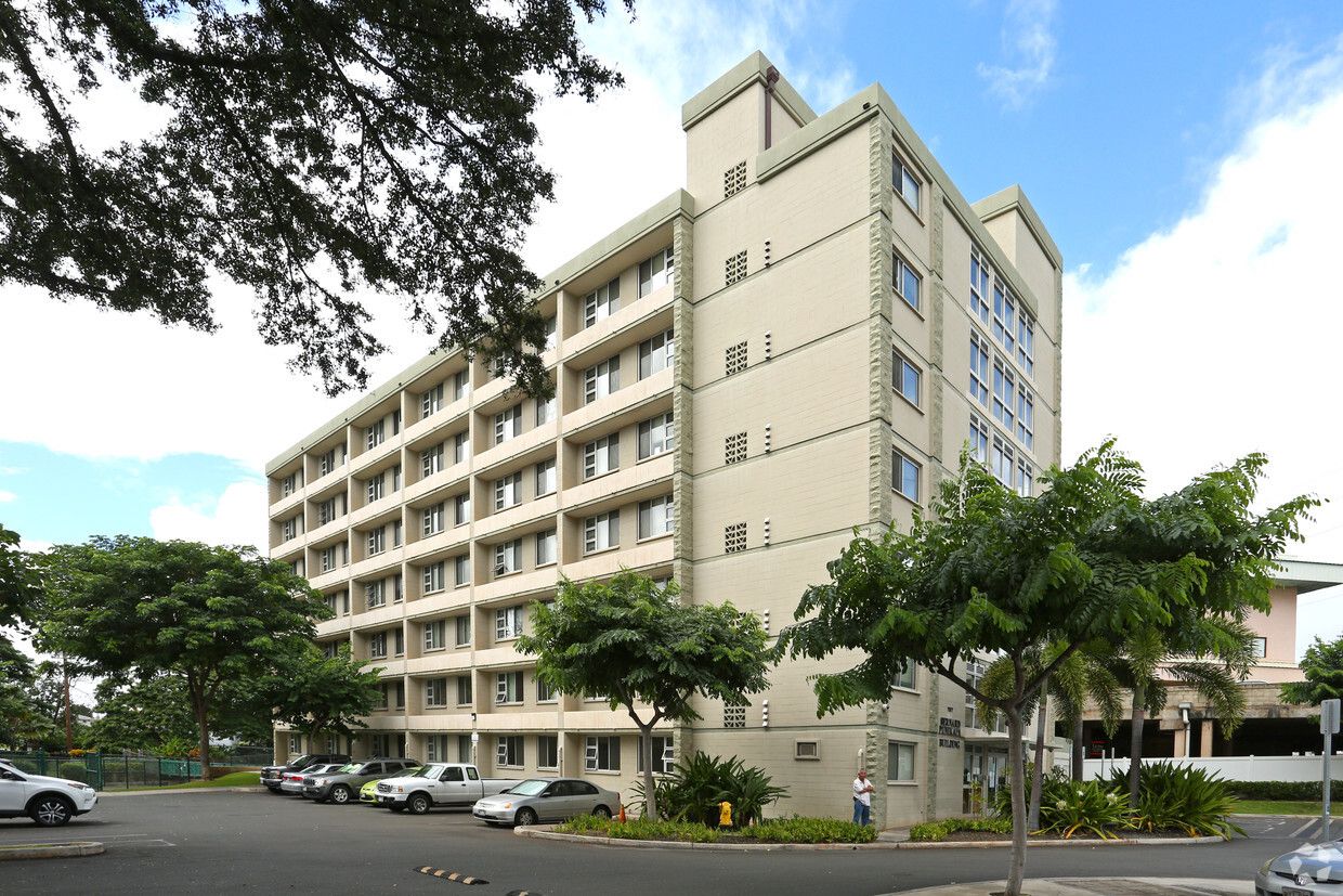 Exterior view of a senior living facility surrounded by greenery