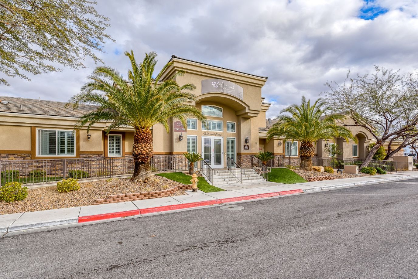 Exterior view of Legacies Memory Care facility with landscaping
