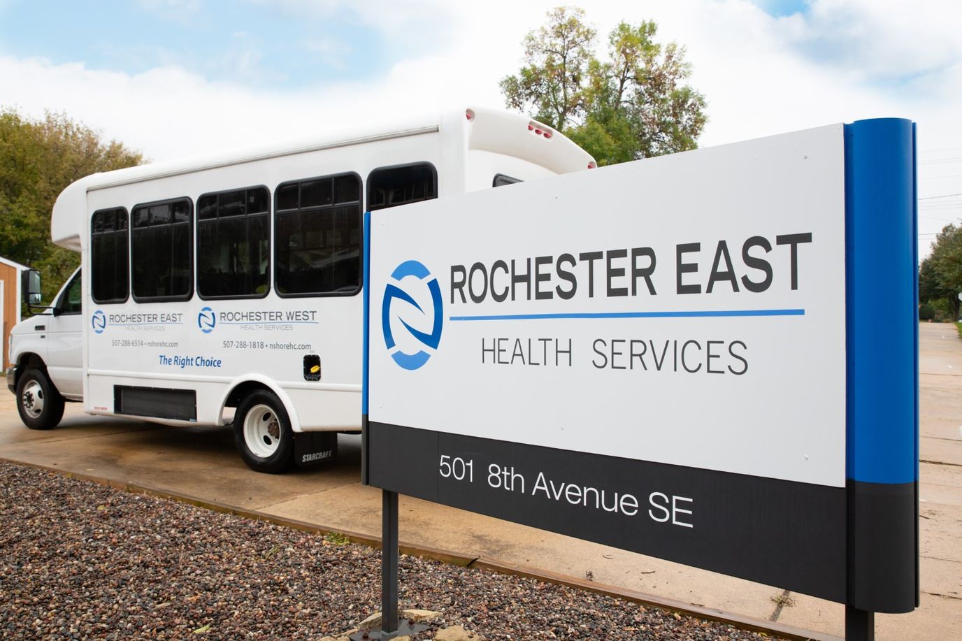Facility sign with a shuttle bus parked nearby