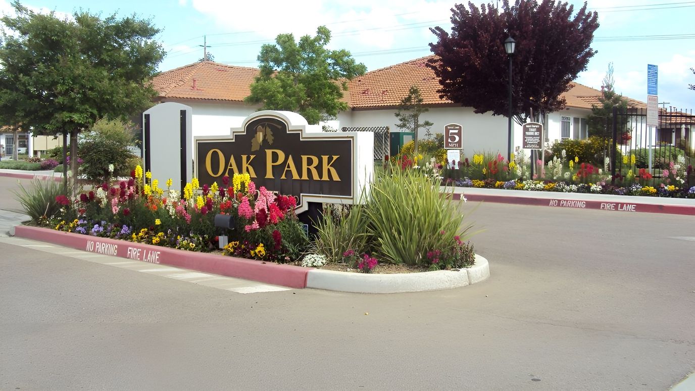 Entrance sign and vibrant flower garden at Oak Park