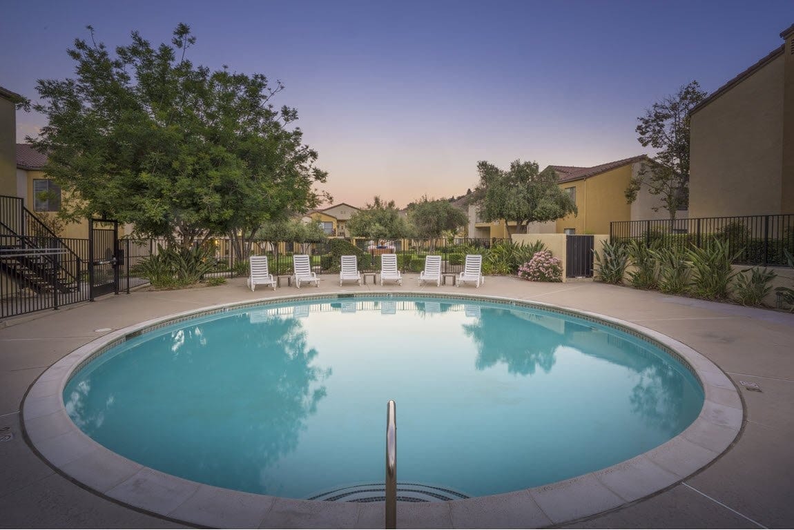 Circular swimming pool surrounded by lounge chairs