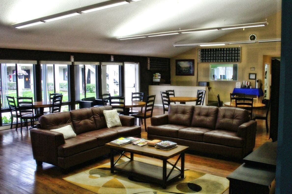 Cozy common area with brown sofas and wooden tables