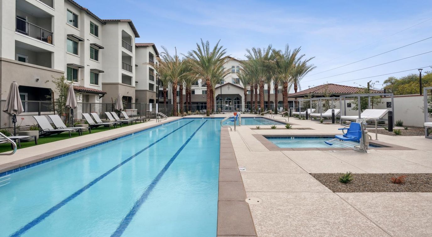 Swimming pool area with palm trees and lounge chairs