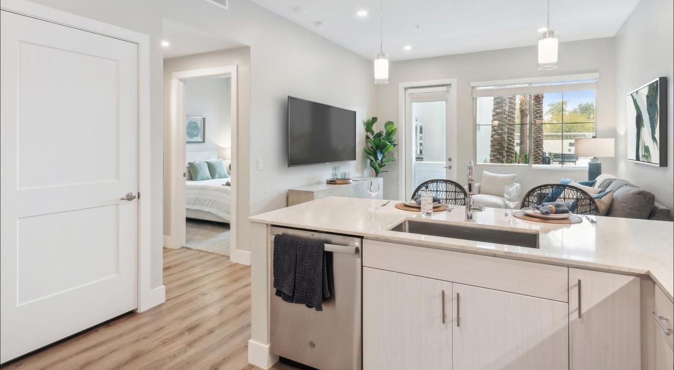 Modern interior view of a senior living unit with living room and kitchen