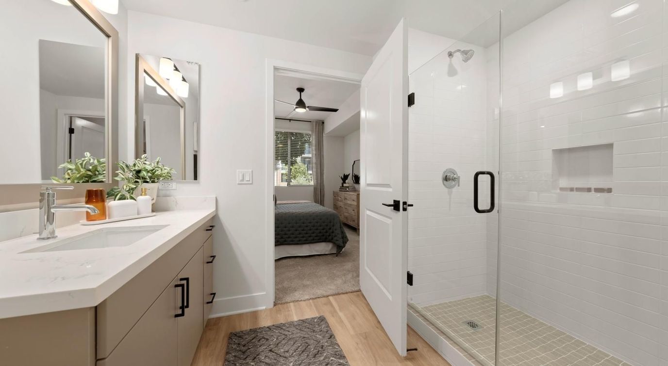 Modern bathroom with shower and bedroom visible