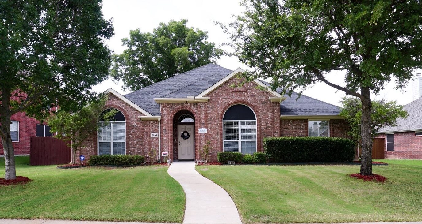 Exterior view of a residential building with a well-maintained lawn