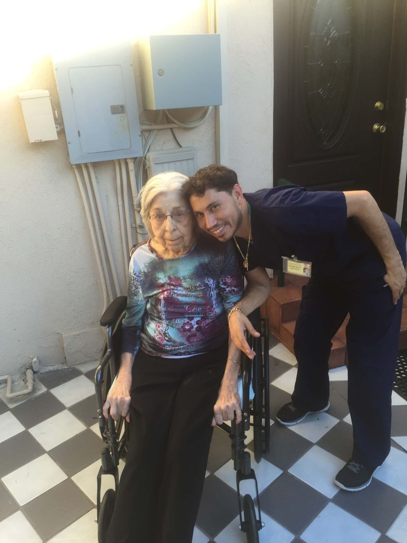 Senior resident and staff member outside the facility