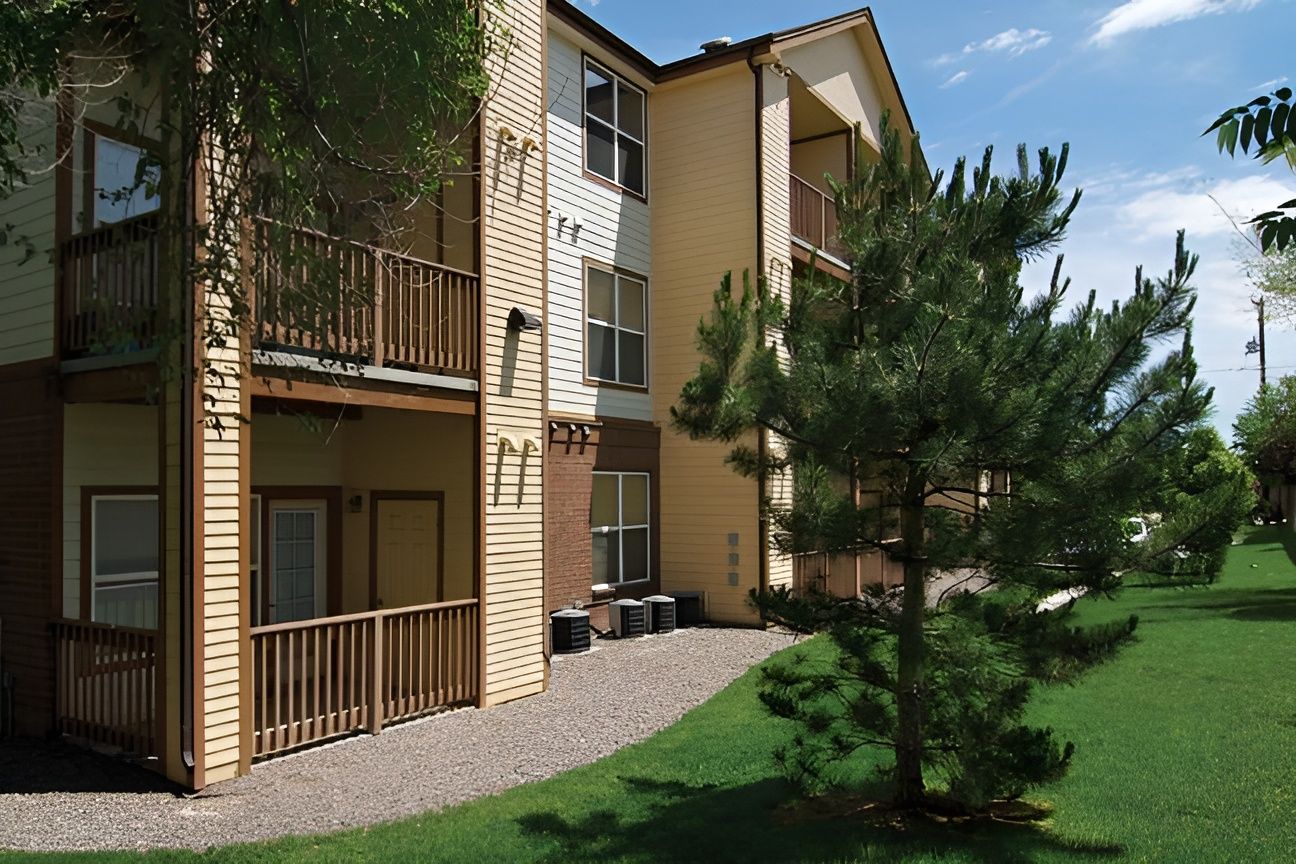 Exterior view of Pinecrest Apartments with landscaping