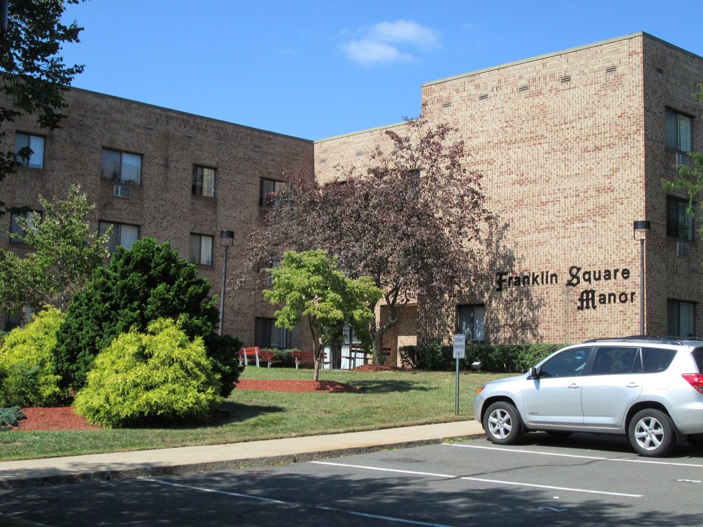 Building exterior of Franklin Square Manor with landscaping