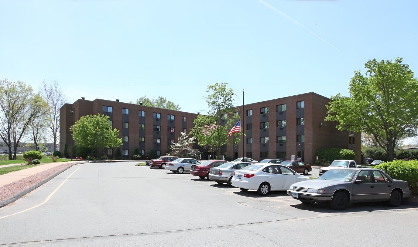 Exterior view of Willow Arms Apartments with parking area