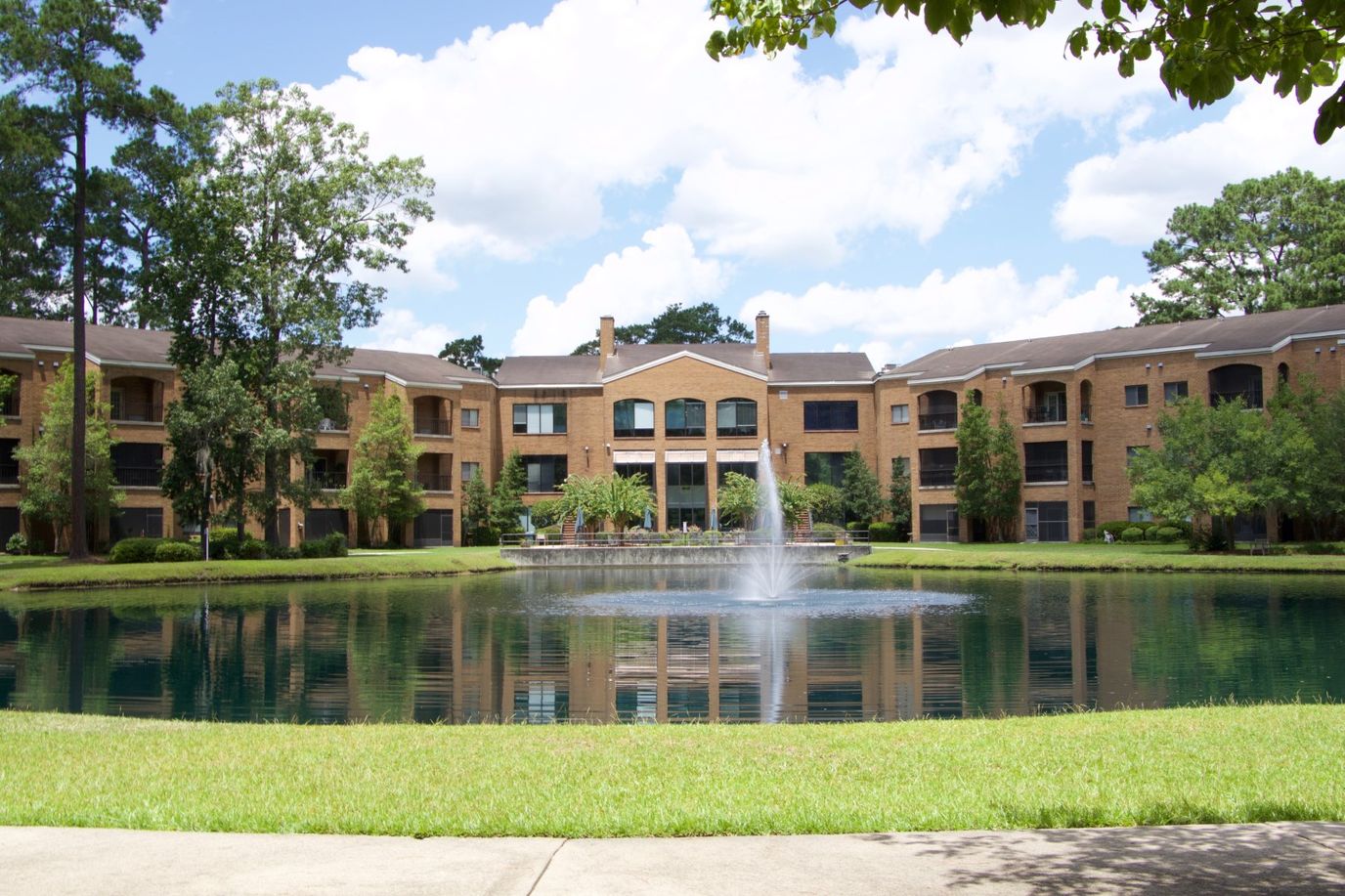 Exterior view of Magnolia Manor with a pond and fountain