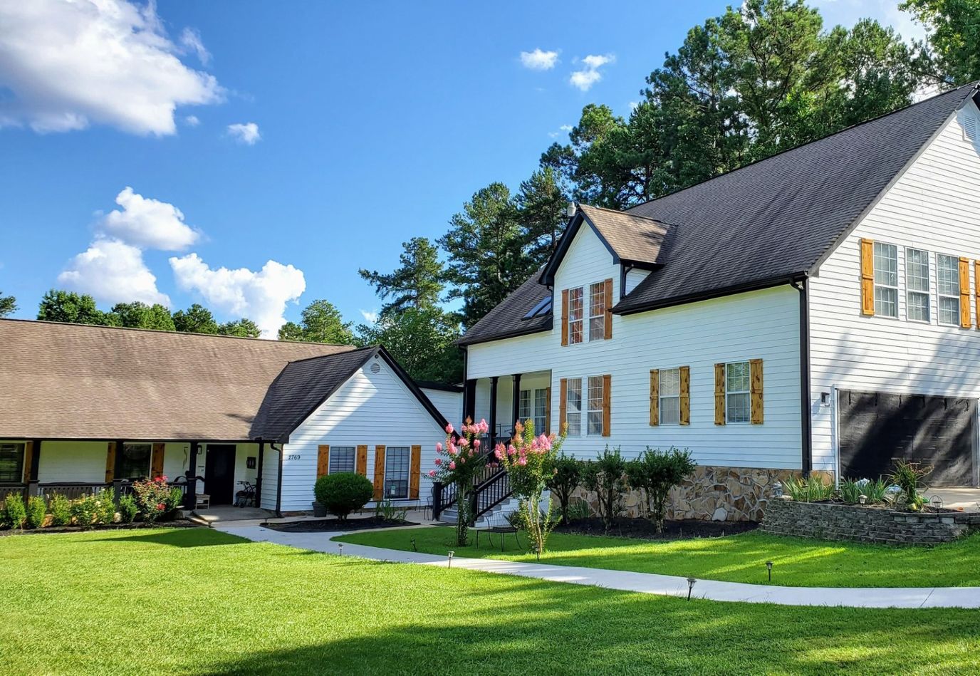 Exterior view of a senior living facility surrounded by gardens