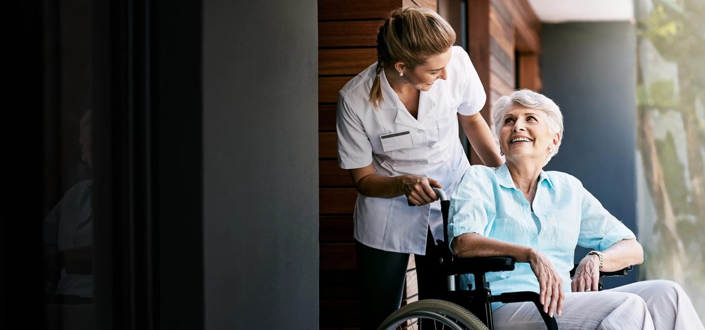 Caregiver assisting a senior woman in a wheelchair