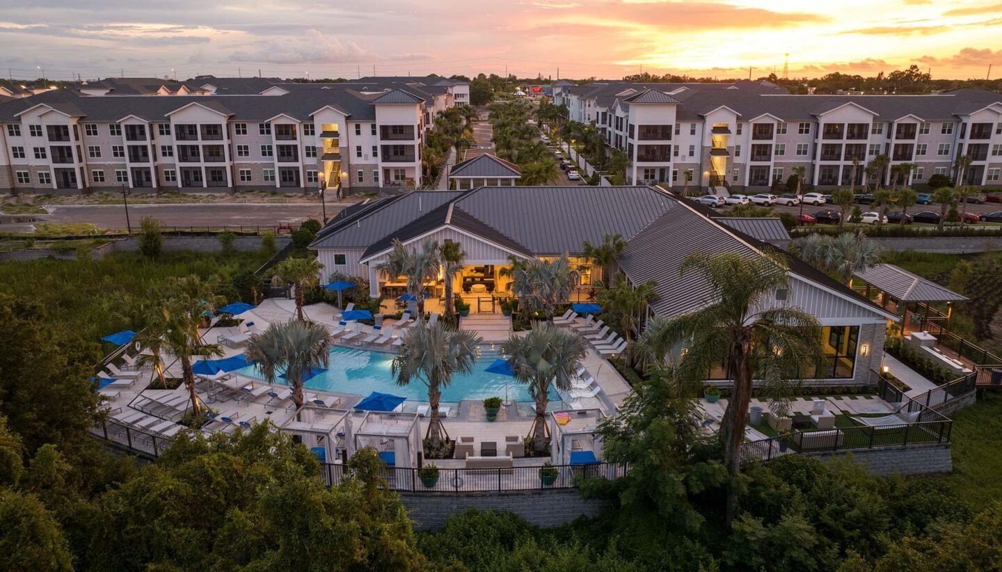 Aerial view of a vibrant outdoor pool area at sunset
