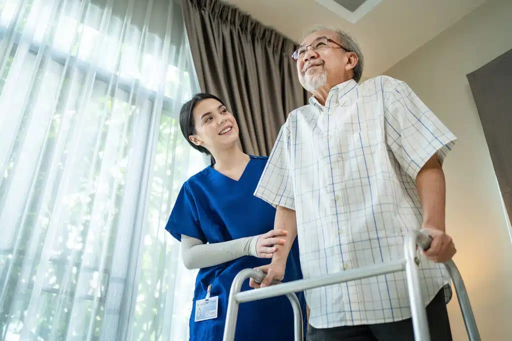 Staff assisting a resident with a walker in a room