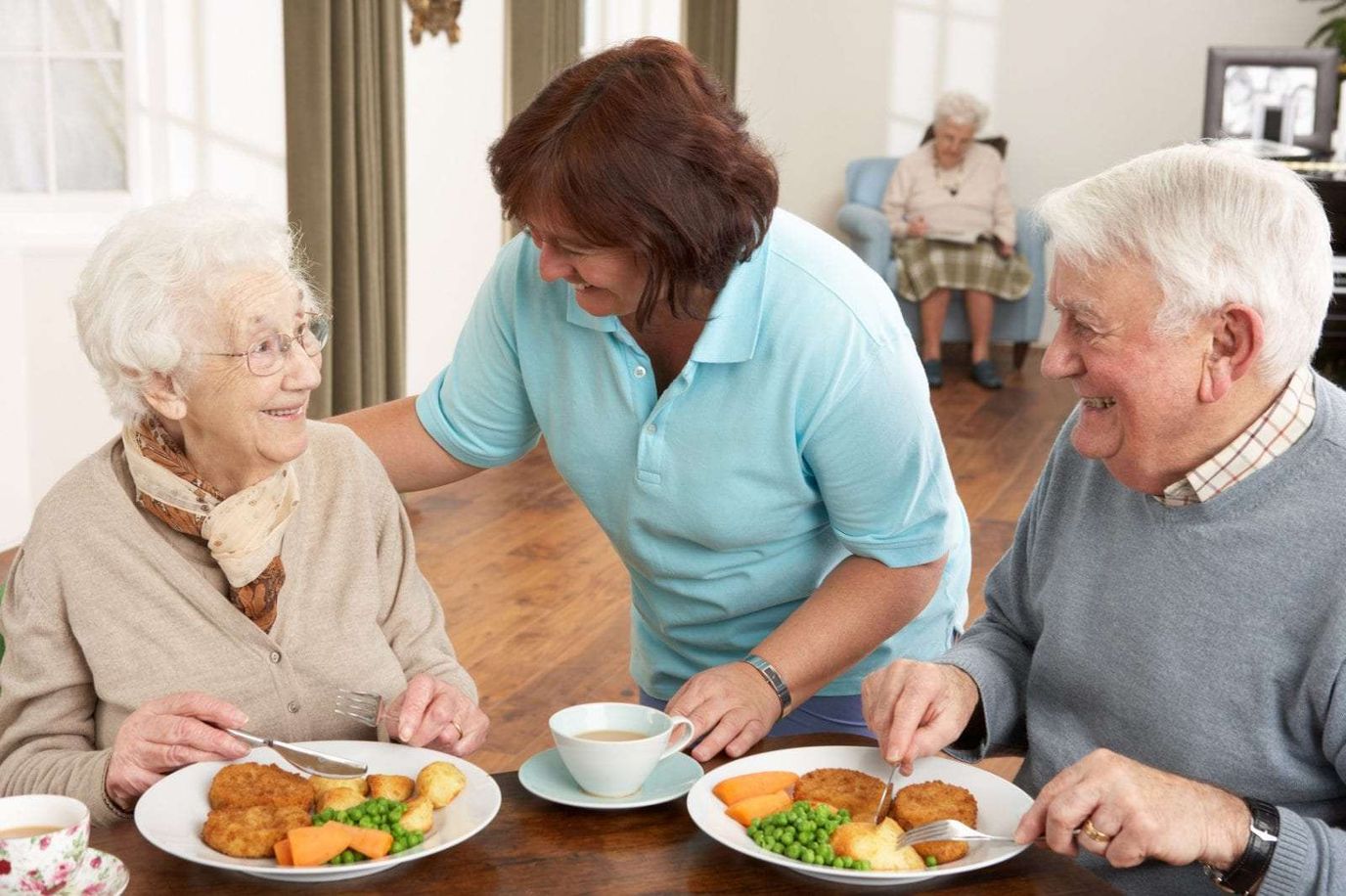 Residents enjoying lunch with staff assistance
