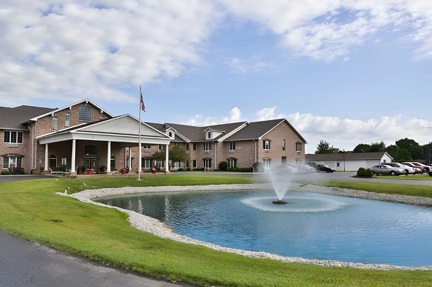 Exterior view of the facility with a pond and flag