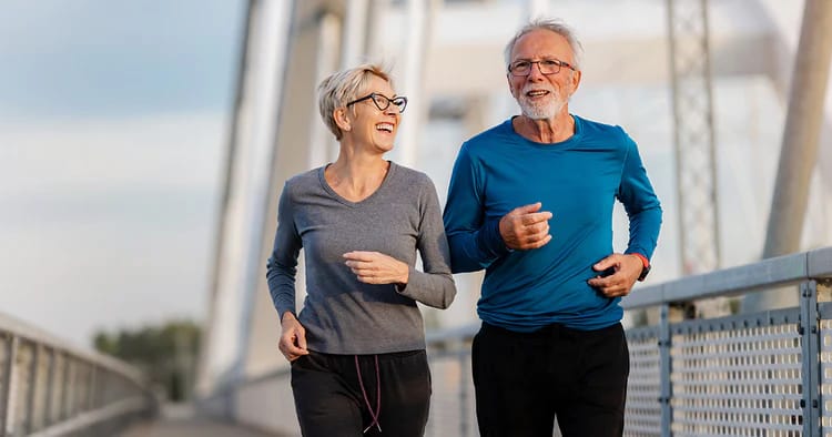 Active seniors jogging on a bridge.