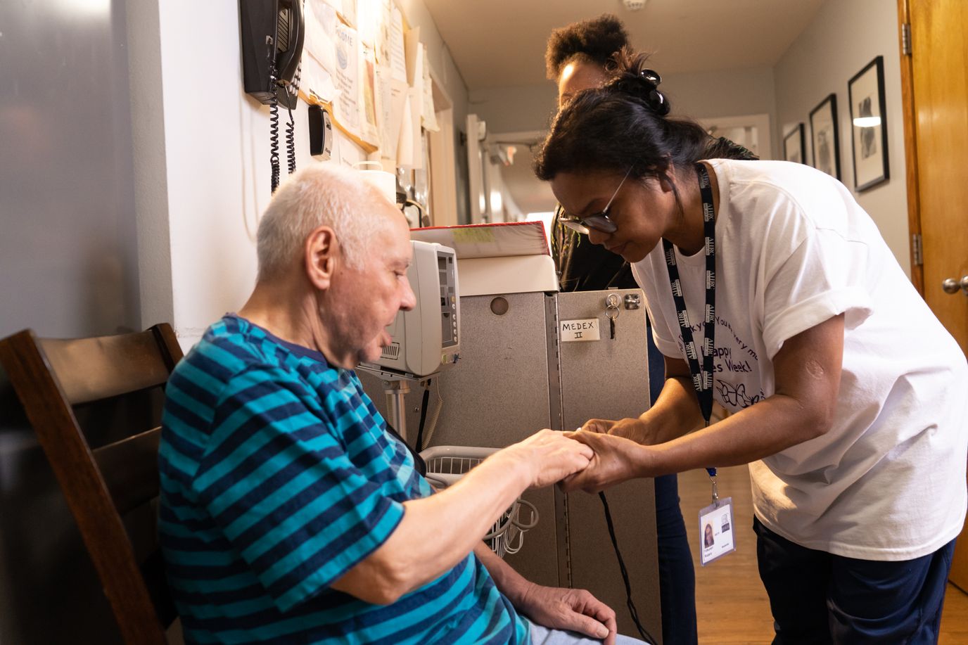Staff interacting with a resident in a hallway